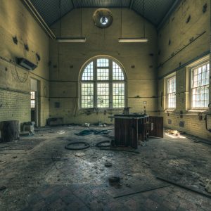 Former psychiatric hospital, regional NSW. Photographer's note: The engineering department workshop that hasn't seen anyone strike a blow for the better part of twenty years. The tiled walls and floor and the grand arch window were pretty fancy for an industrial working area like this.